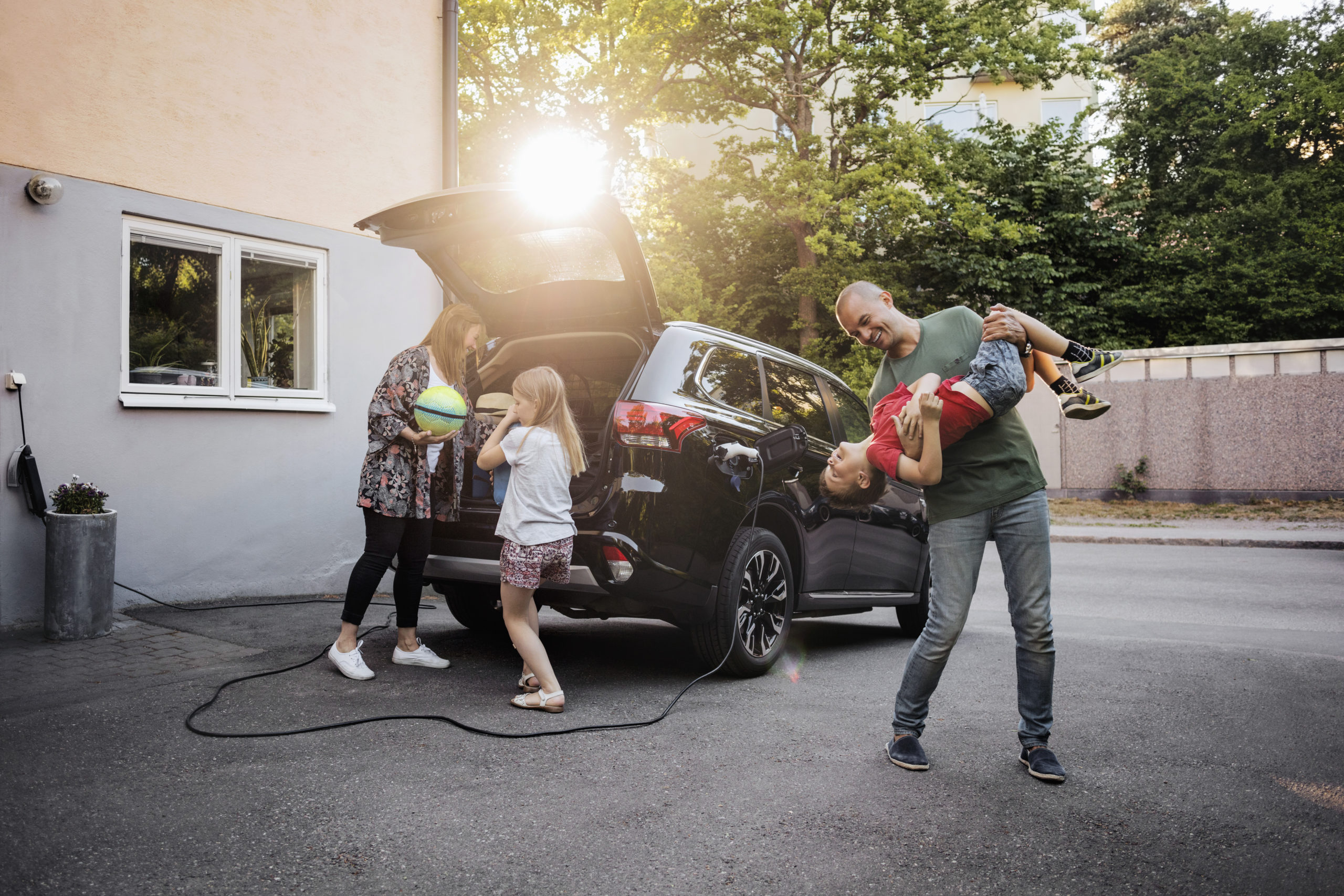 familie-mit-elektro-auto-im-innenhof