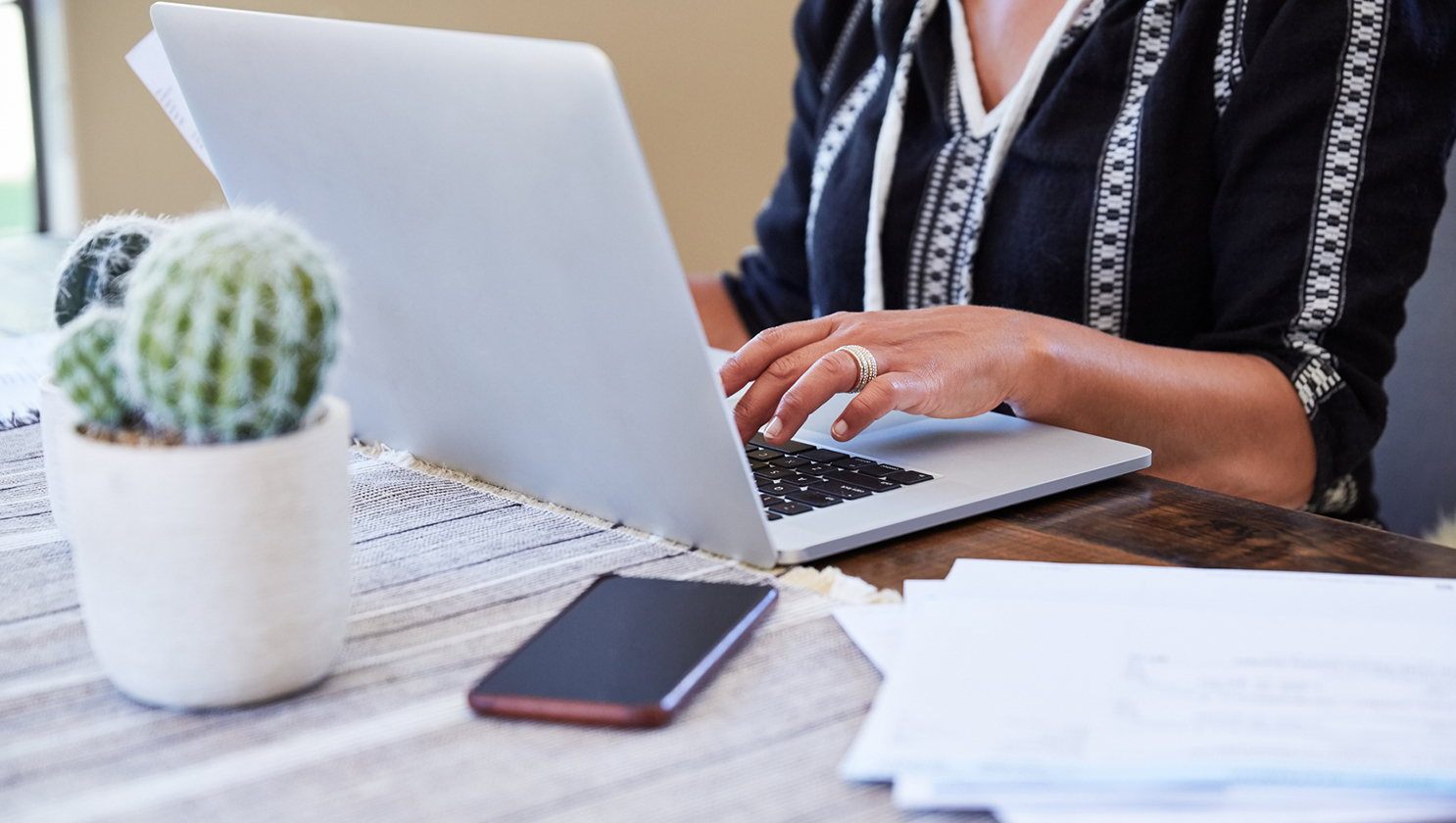 frau-tippt-auf-laptop-am-tisch-liegt-telefon