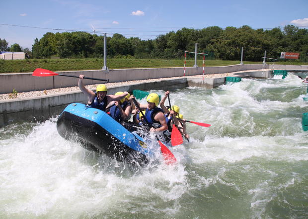 Zu sehen ist ein vollbefülltes Rafting-Boot im Einsatz.